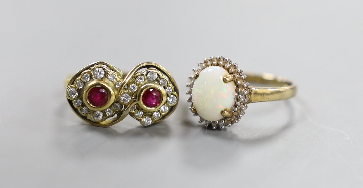 A modern yellow metal ruby? and diamond set double cluster ring, size N, gross weight 6.3 grams and a modern 9ct gold, white opal and diamond chip set oval cluster ring, gross weight 2.3 grams.